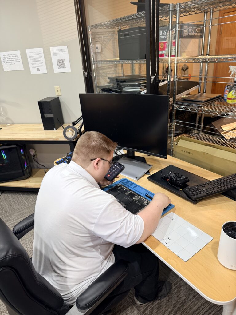 Technician working on a desktop computer at the KC Computer Staff repair bench