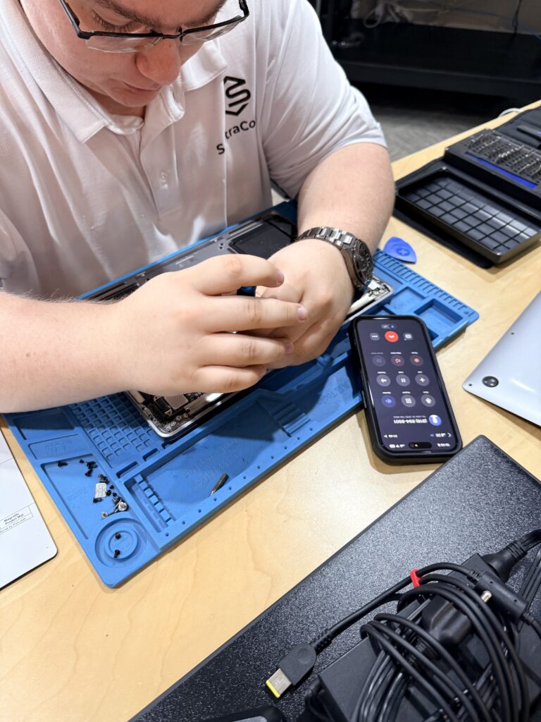 Technician repairing a laptop on an anti-static mat at KC Computer Staff